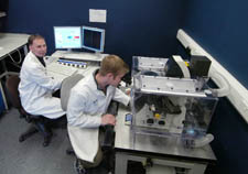 picture shows from left to right Dr Calum Sutherland and Craig Beall, the latter looking into the microscope